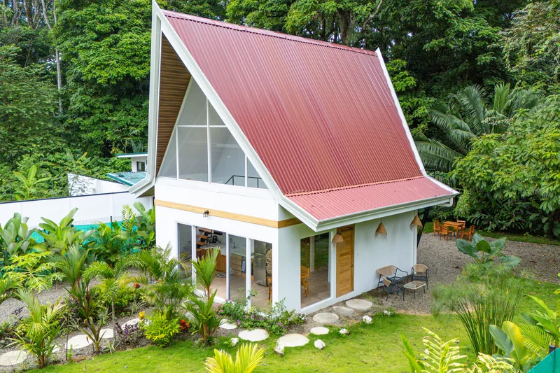 Vista aérea de Crystal Jungle Villa — techo rojo tipo A-frame rodeado de selva tropical